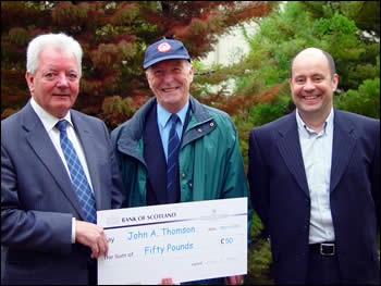Mr Thomson receiving his cheque